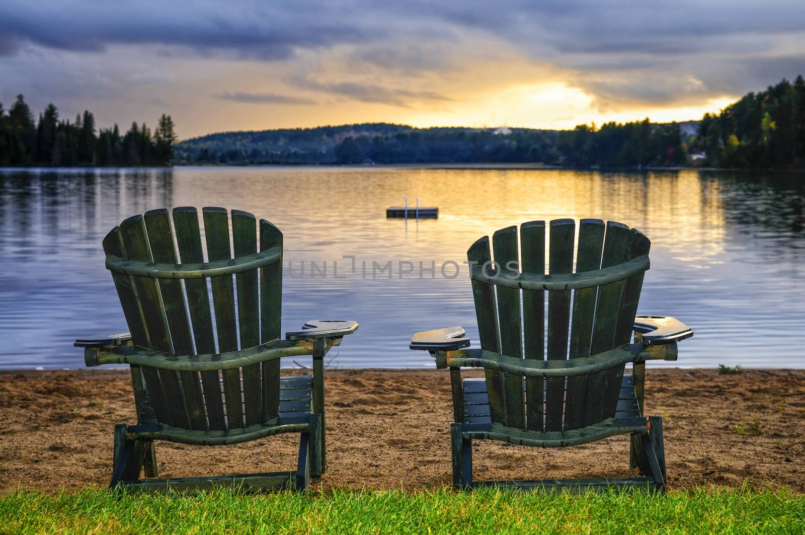 Wooden chairs at sunset on beach by elenathewise