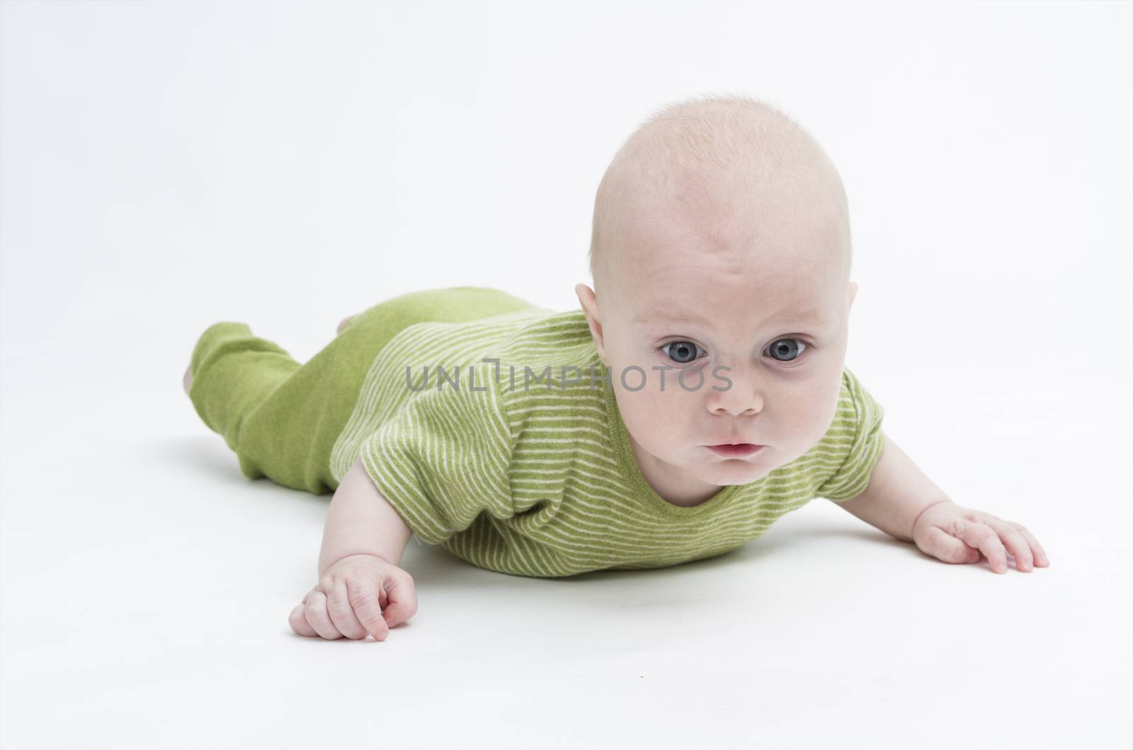 crawling baby in green romper suit isolated on white background. studio shot