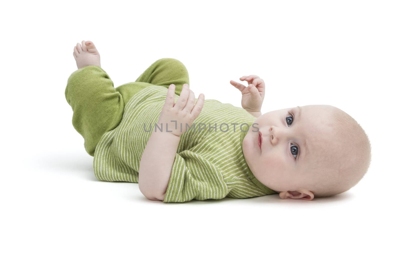 toddler in green clothing laying on back in white background