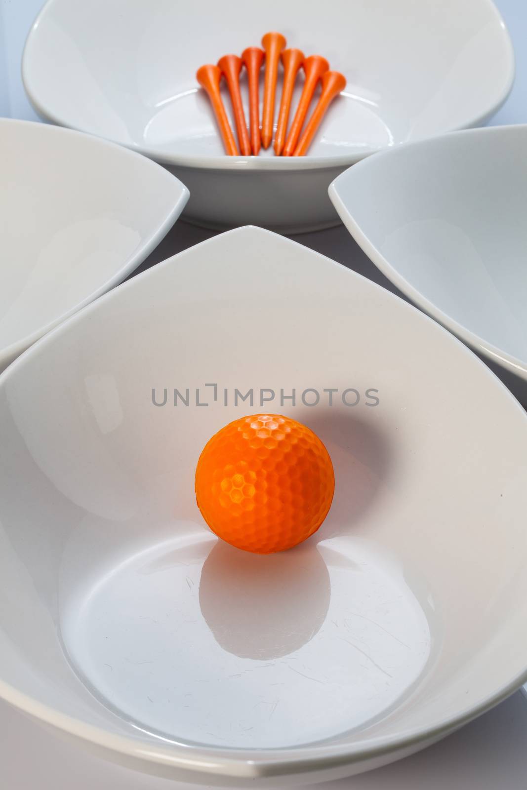 Four white ceramics bowls and golf ball