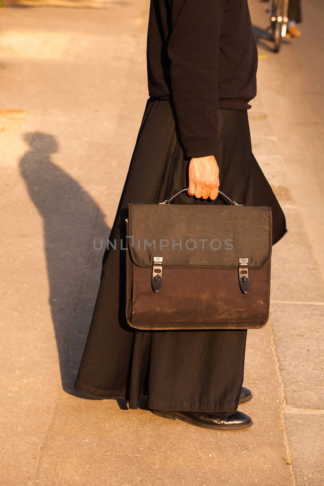 The detail of the priest on the street in Paris, France by CaptureLight