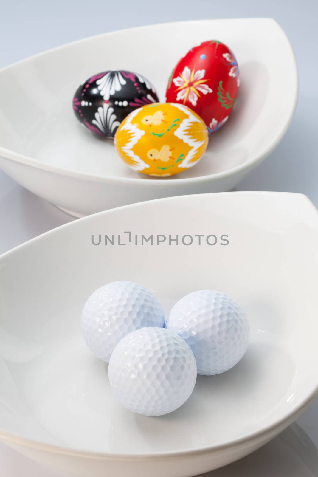 Two white ceramics bowls,golf balls and easter eggs