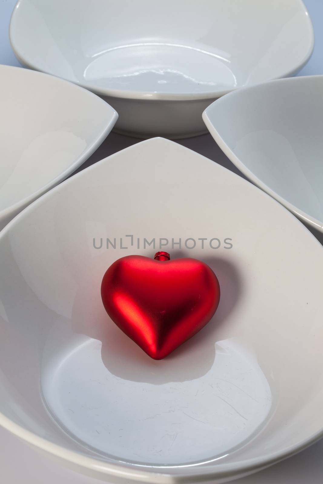 Four white ceramics bowls and red heart
