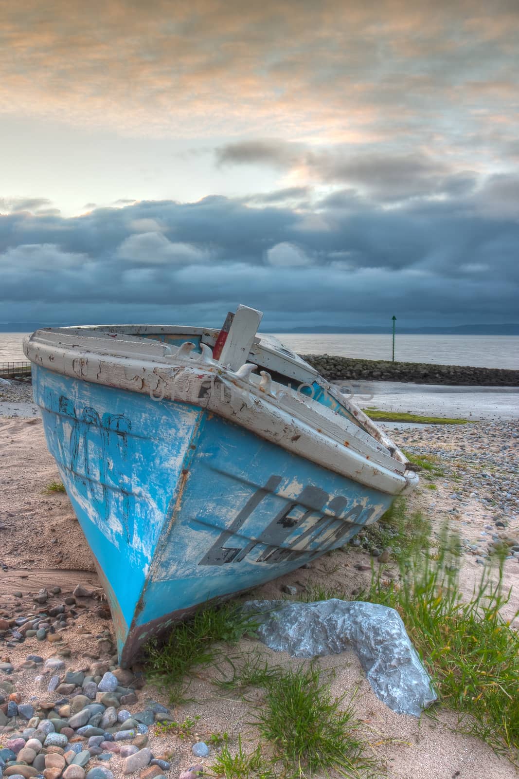 Damaged fishing boat on the empty beach in Morecambe, England, HDR Image