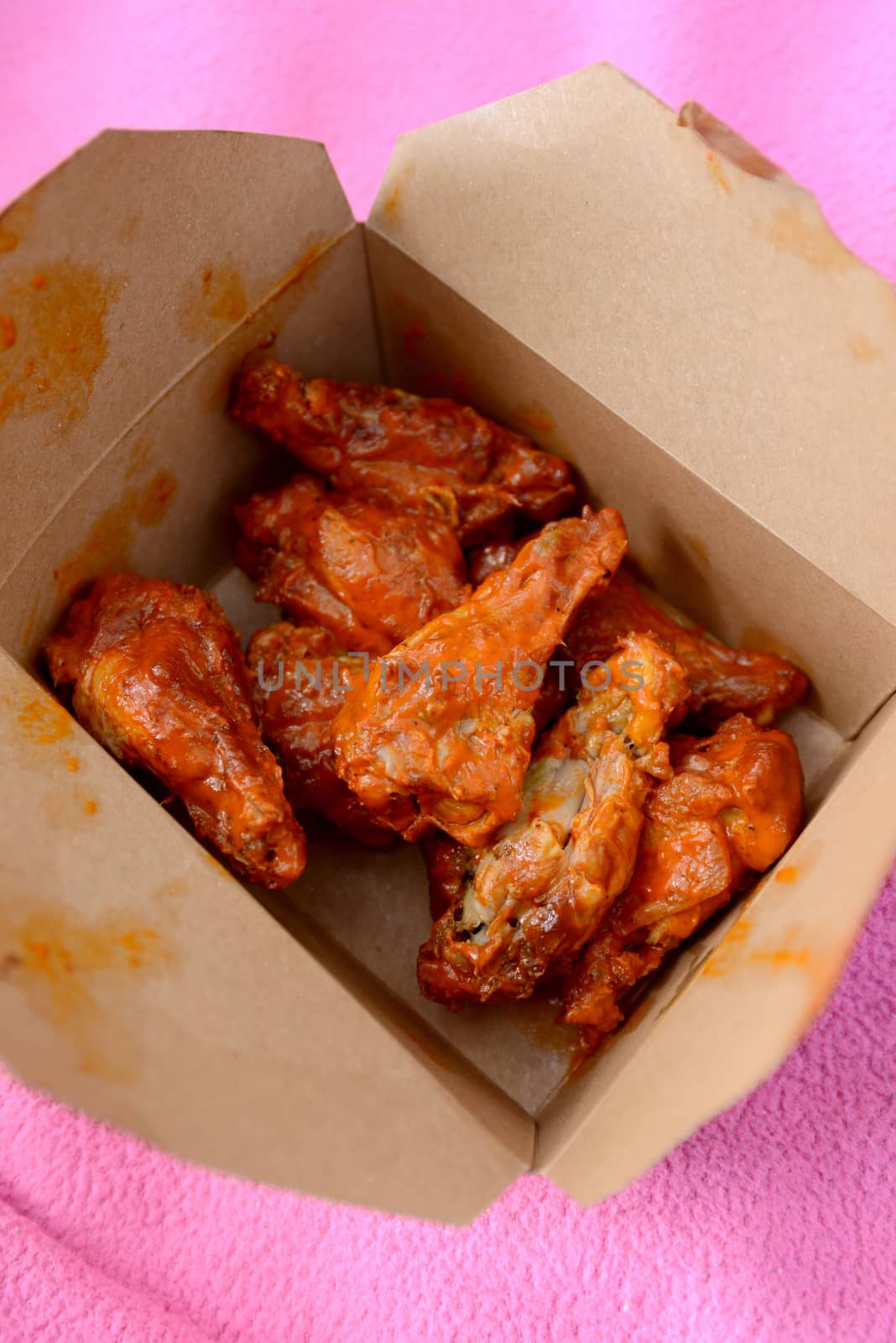 takeout box of spicy buffalo wings and drumsticks