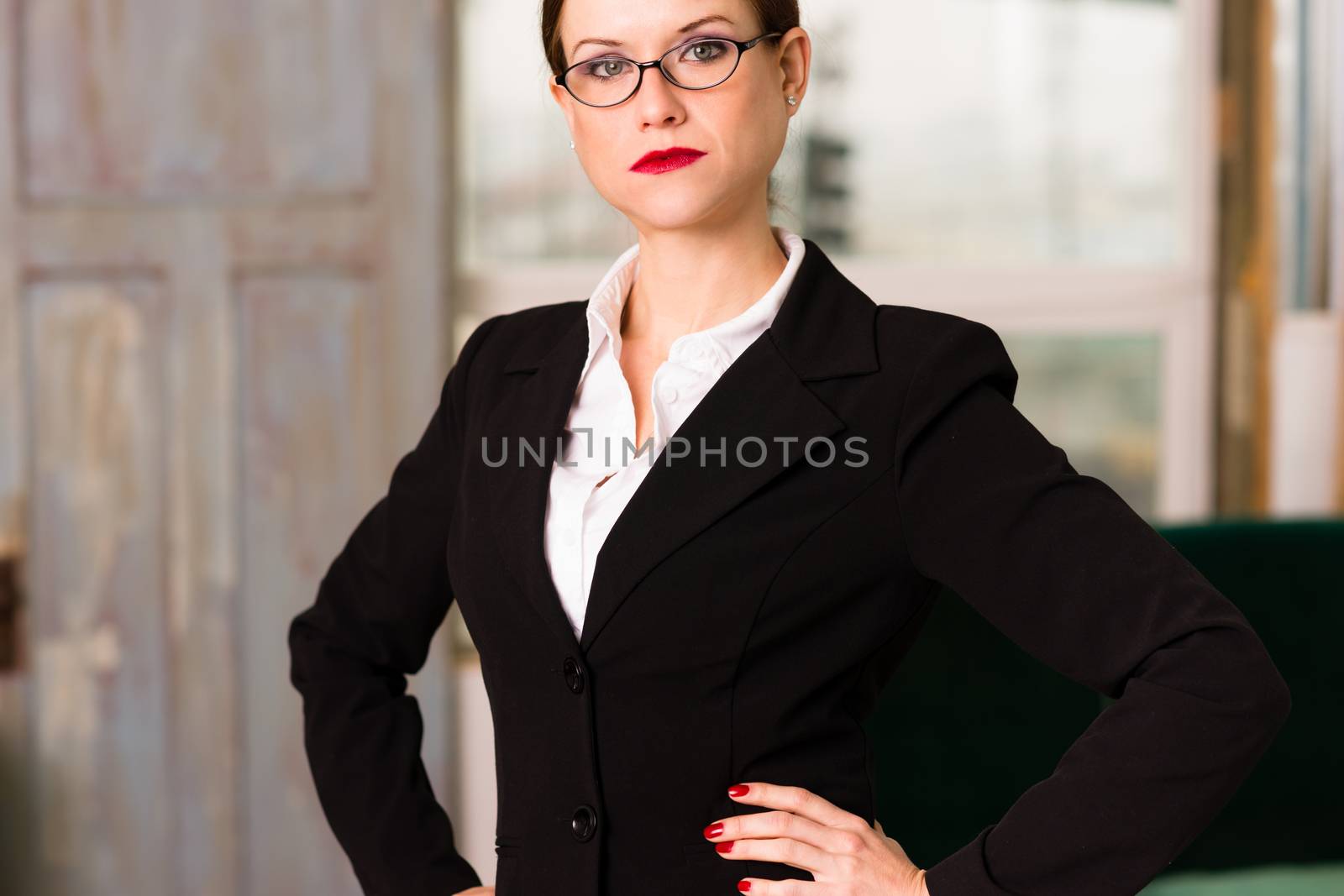 Beautiful brunette business woman hands on hips looking serious