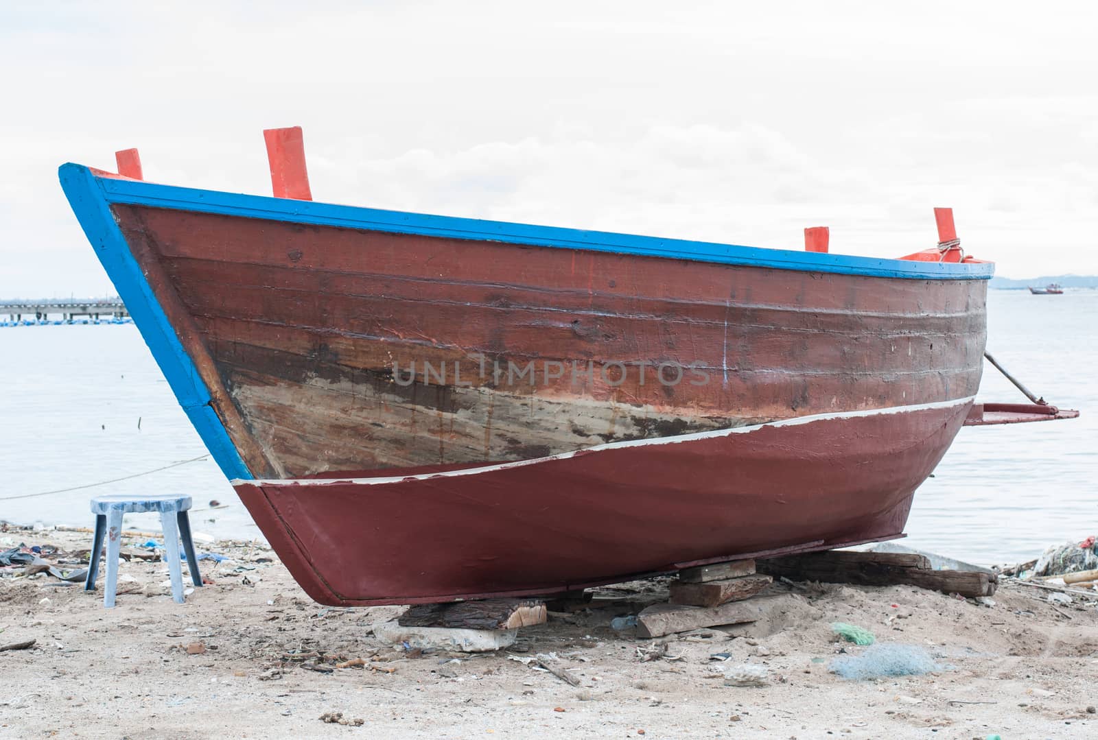 Old wooden boat on the shore waiting for repair.