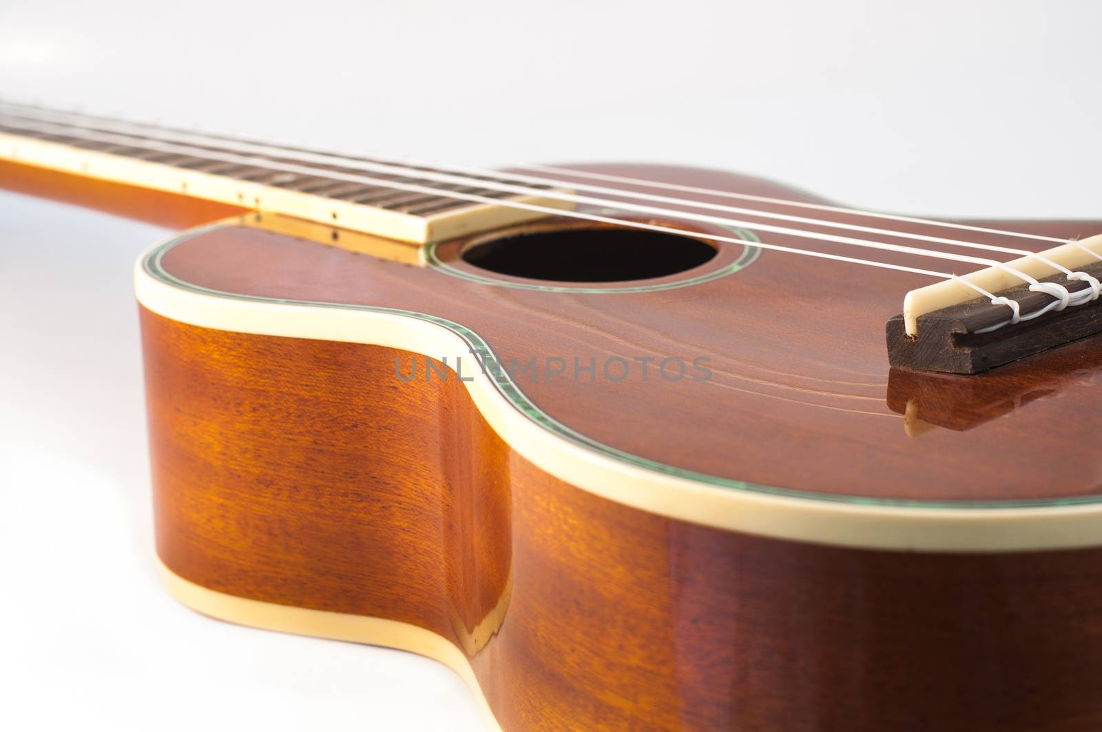 Ukulele guitar brown color and a white background