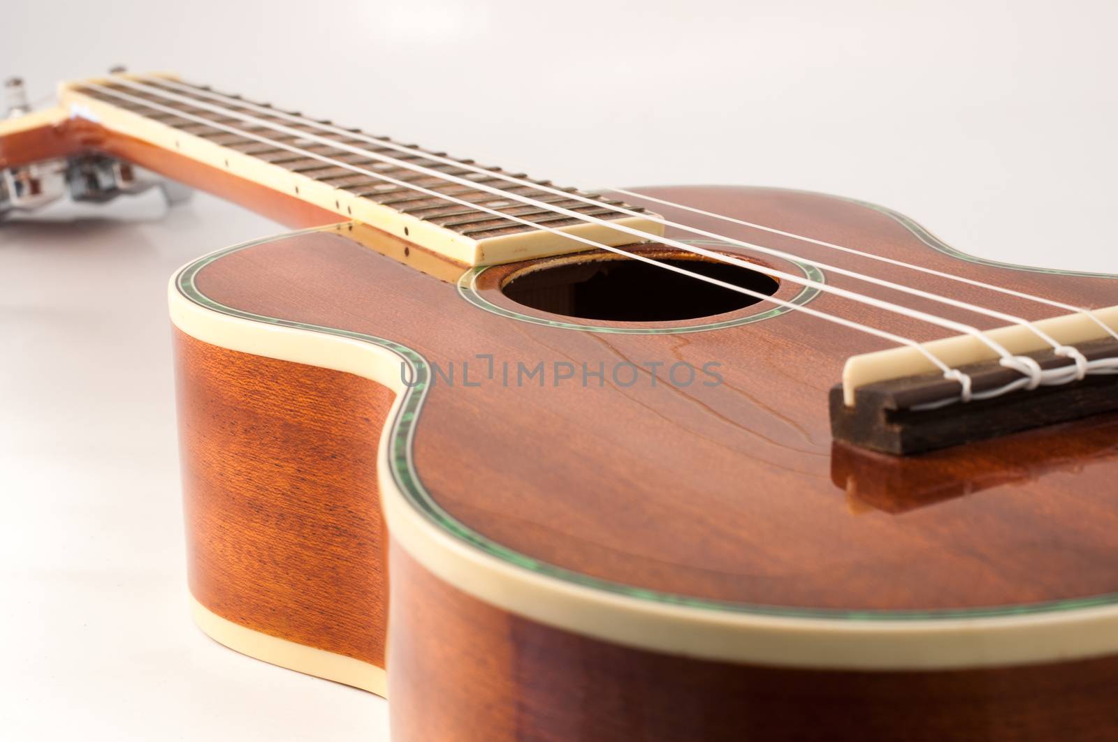 Ukulele guitar brown color and a white background