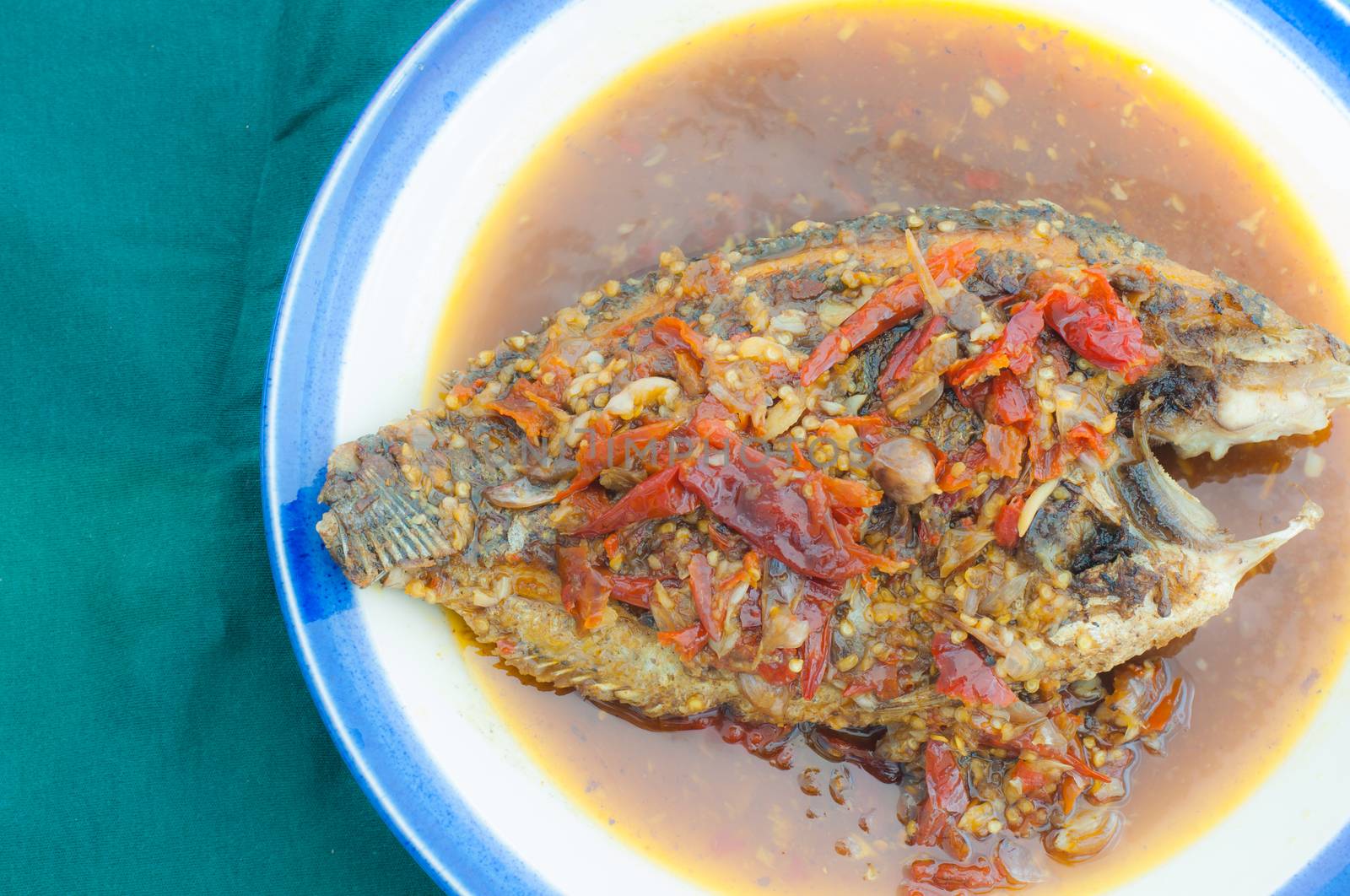 A deep fried fish topped with chili.