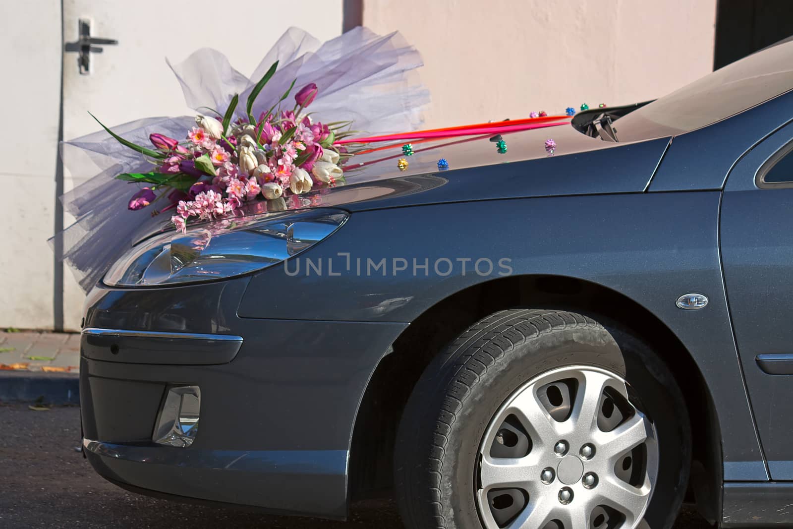 On  hood of  car is  bridal bouquet.