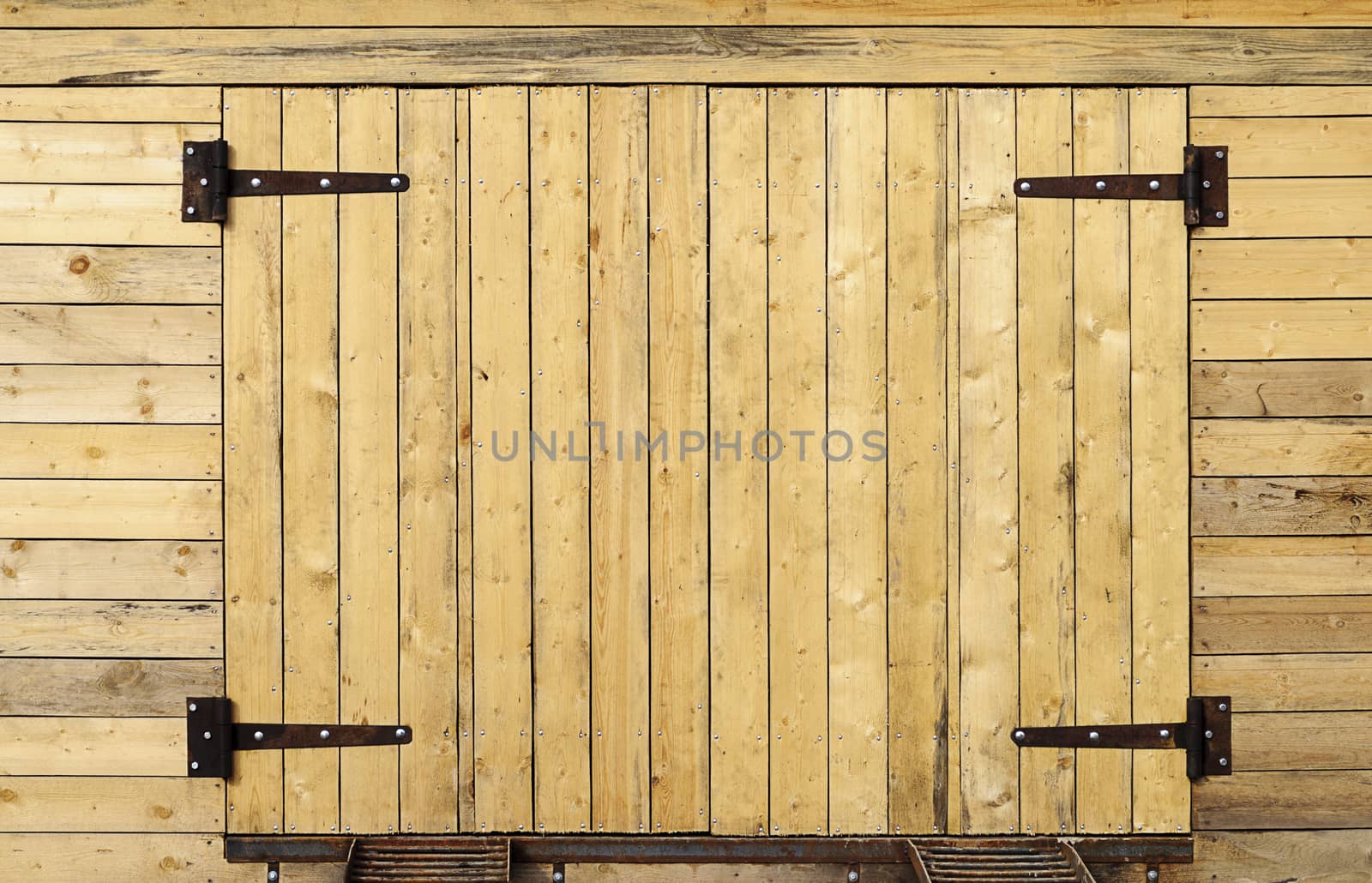 New unpainted wooden garage door with metal hinges