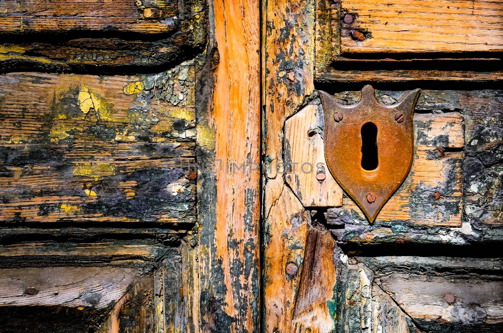 Detail of vintage key hole on weathered wooden door