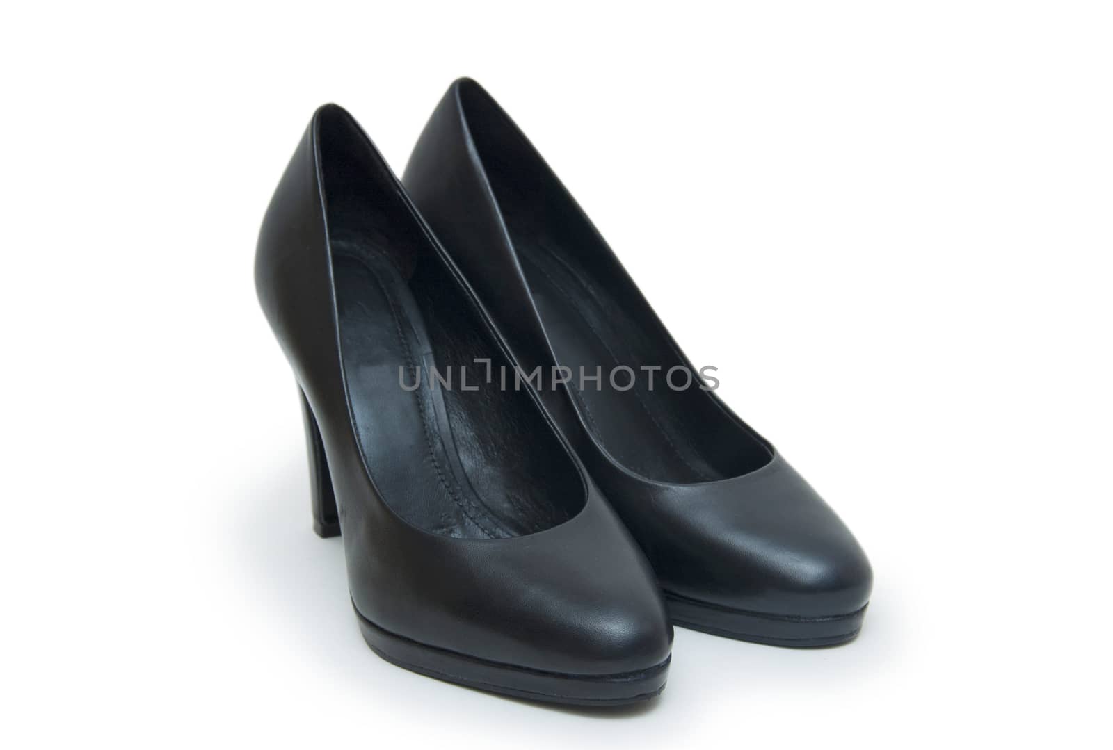 Close-up of female high-heeled shoes over white background  by cocoo