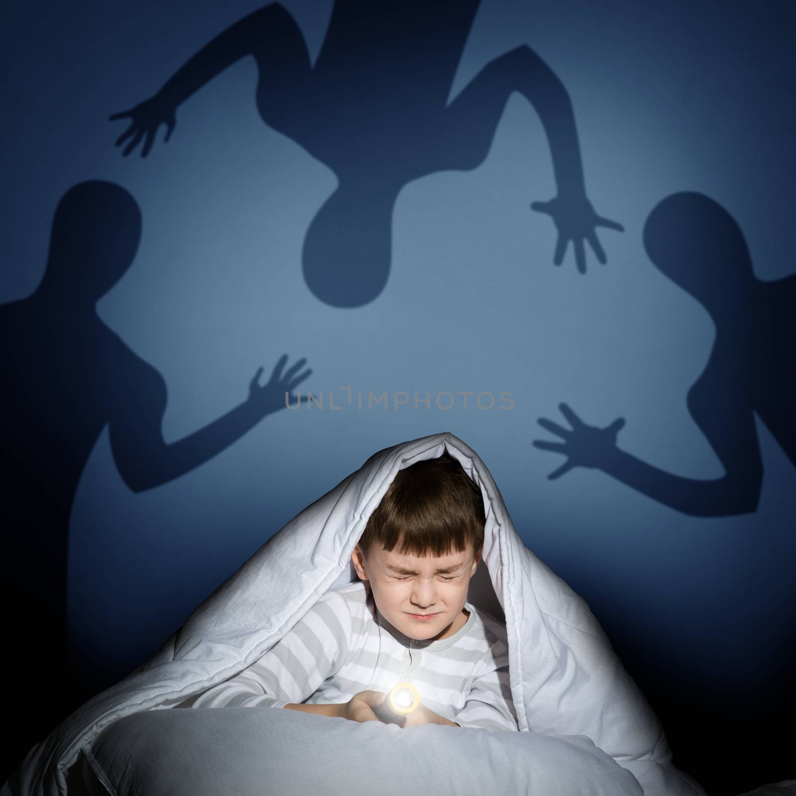 boy under the covers with a flashlight by adam121