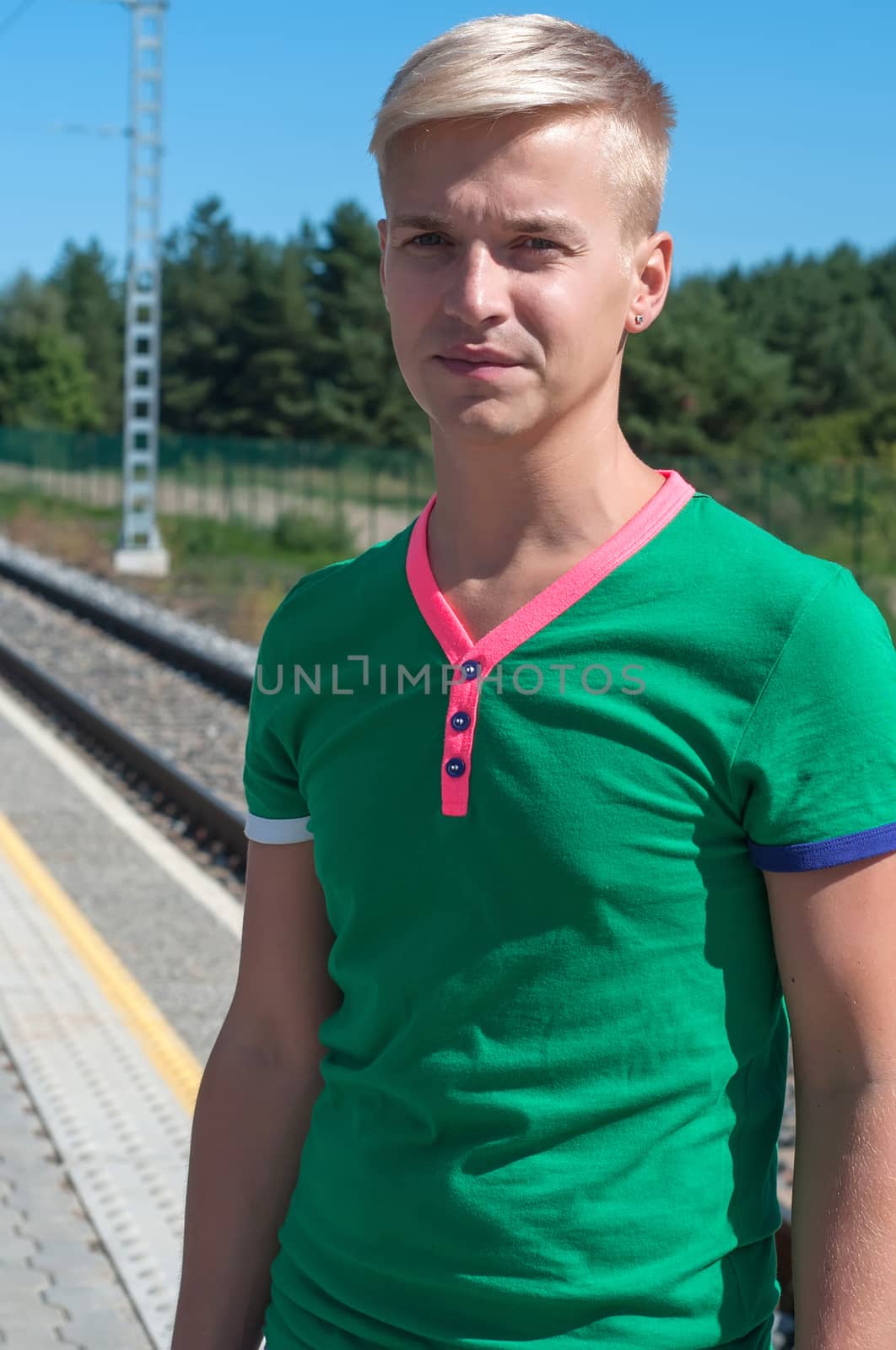 Shot of stylish man in green t-shirt standing on platform