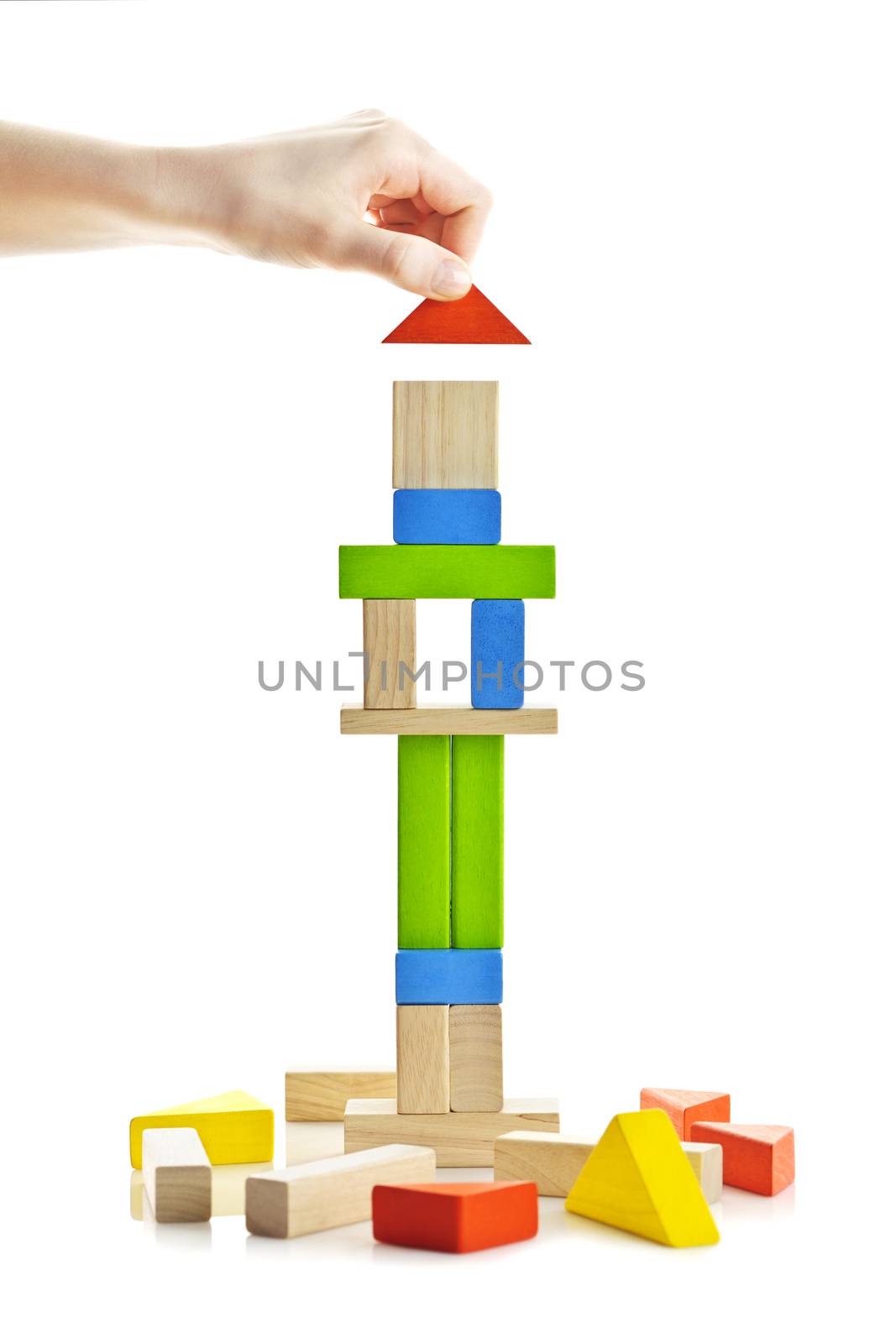 Hand building tower of wooden blocks isolated on white background