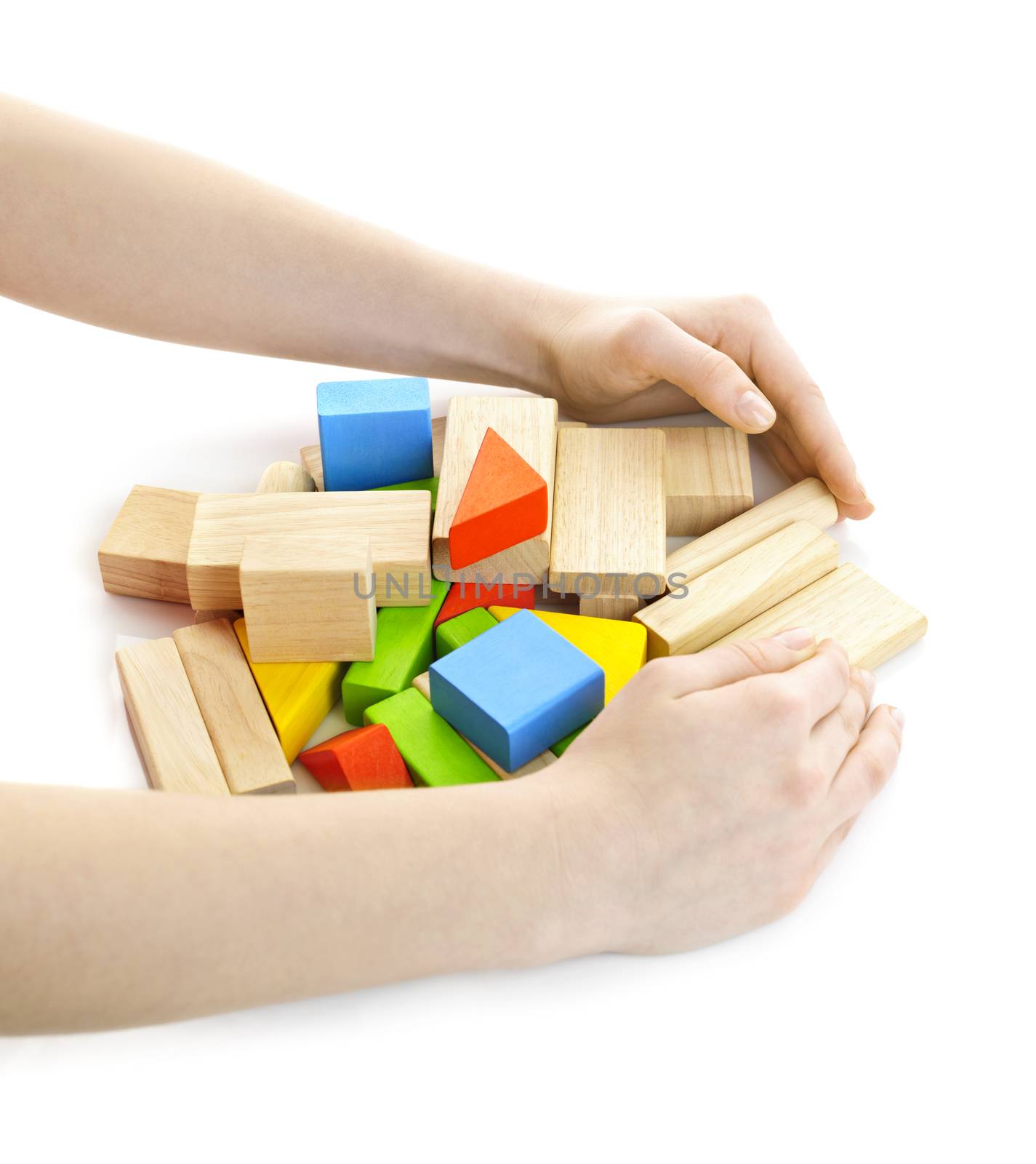 Hands gathering pile of wooden block toys isolated on white