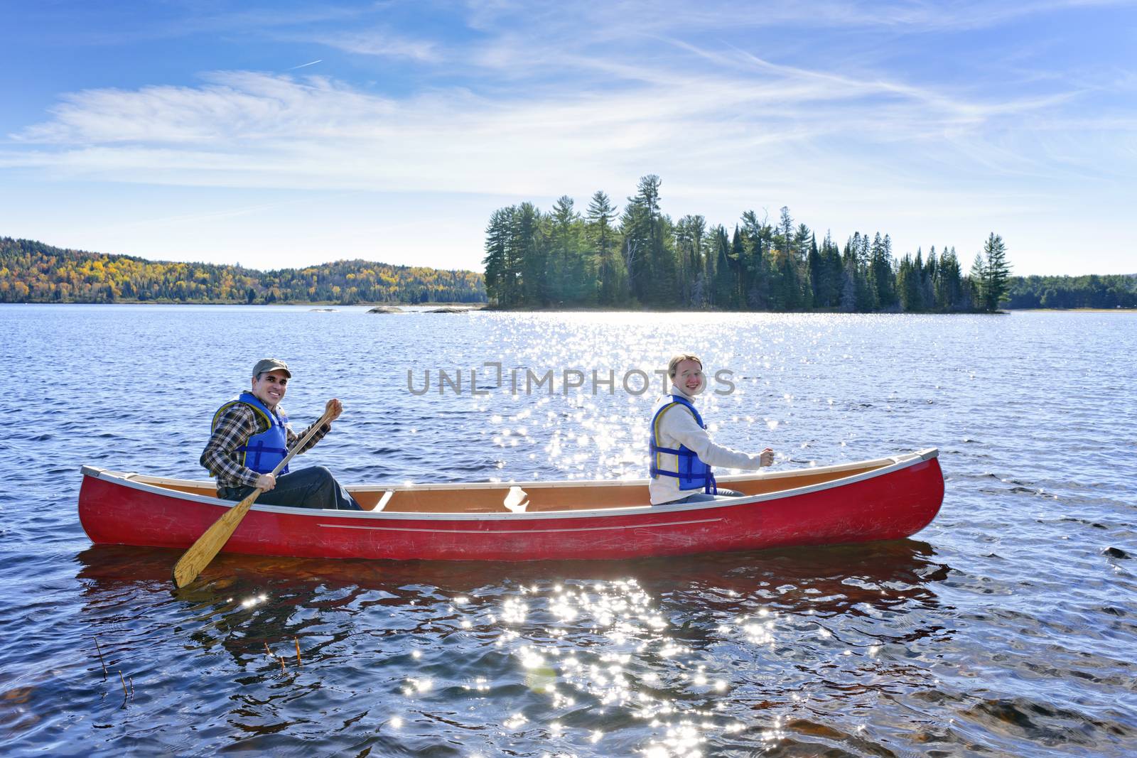 Family canoeing on sunny Lake of Two Rivers, Ontario, Canada