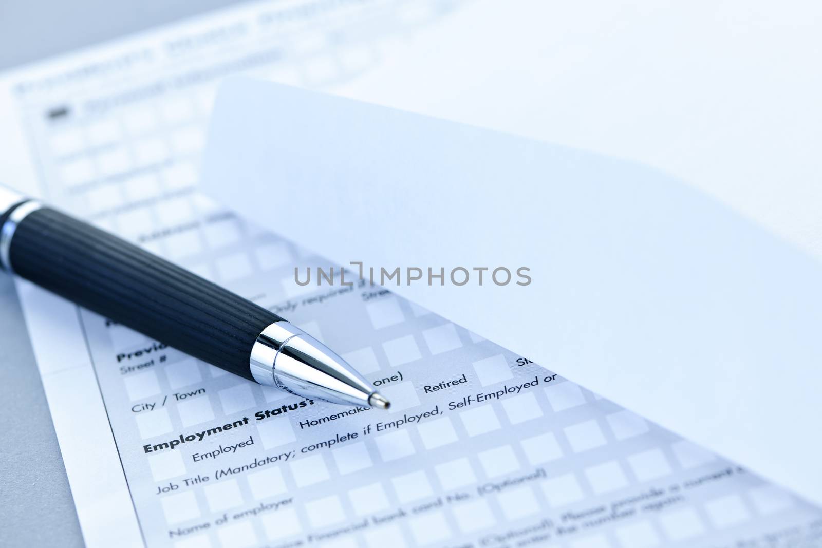 Blank credit application form with envelope and pen close up