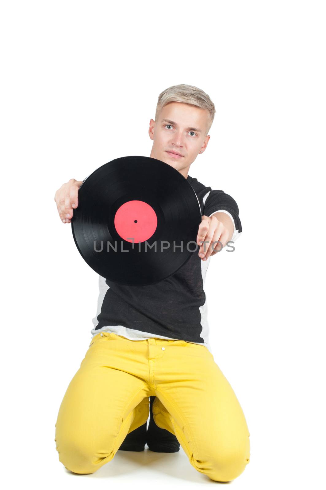 Young man showing from vinyl record and sitting on the floor