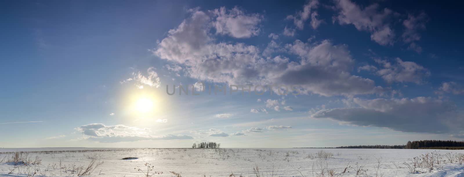 sunset over a snow-covered field in the winter