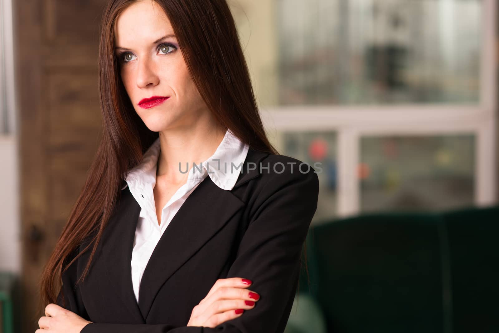 Beautiful young adult woman looks right at camera in the office