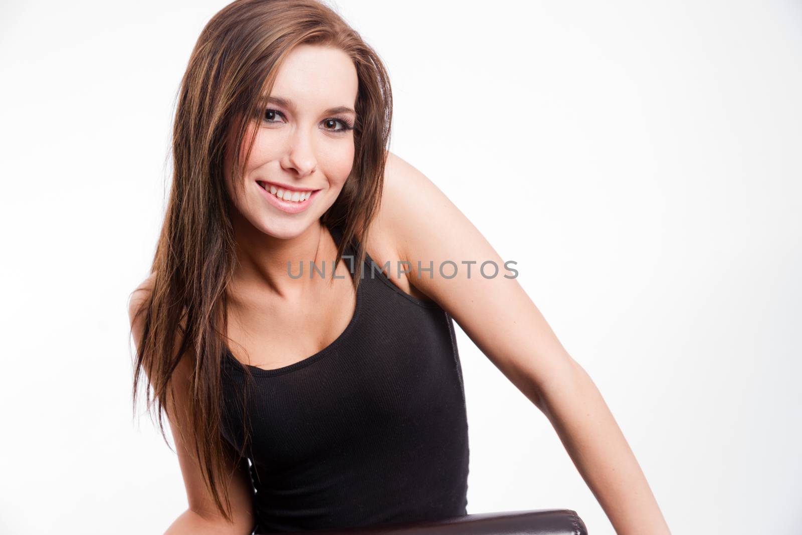 Young woman straddling common chair looking happy by ChrisBoswell