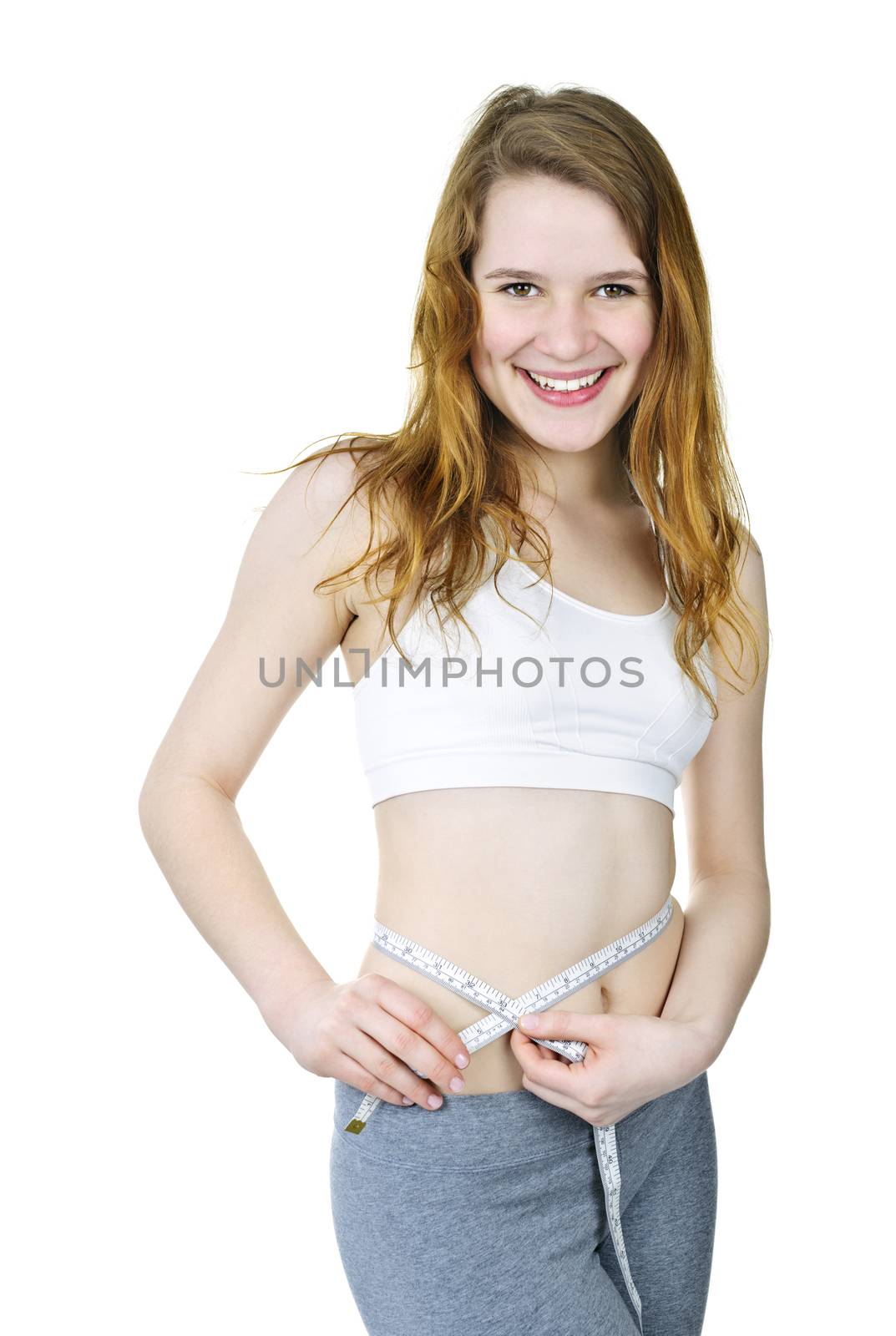 Happy fit young woman measuring waist with tape isolated on white