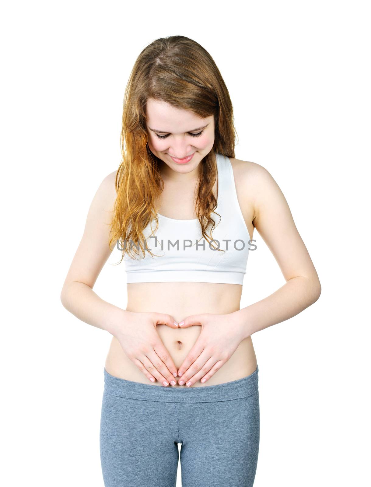 Happy young woman with heart shaped hands on stomach isolated on white