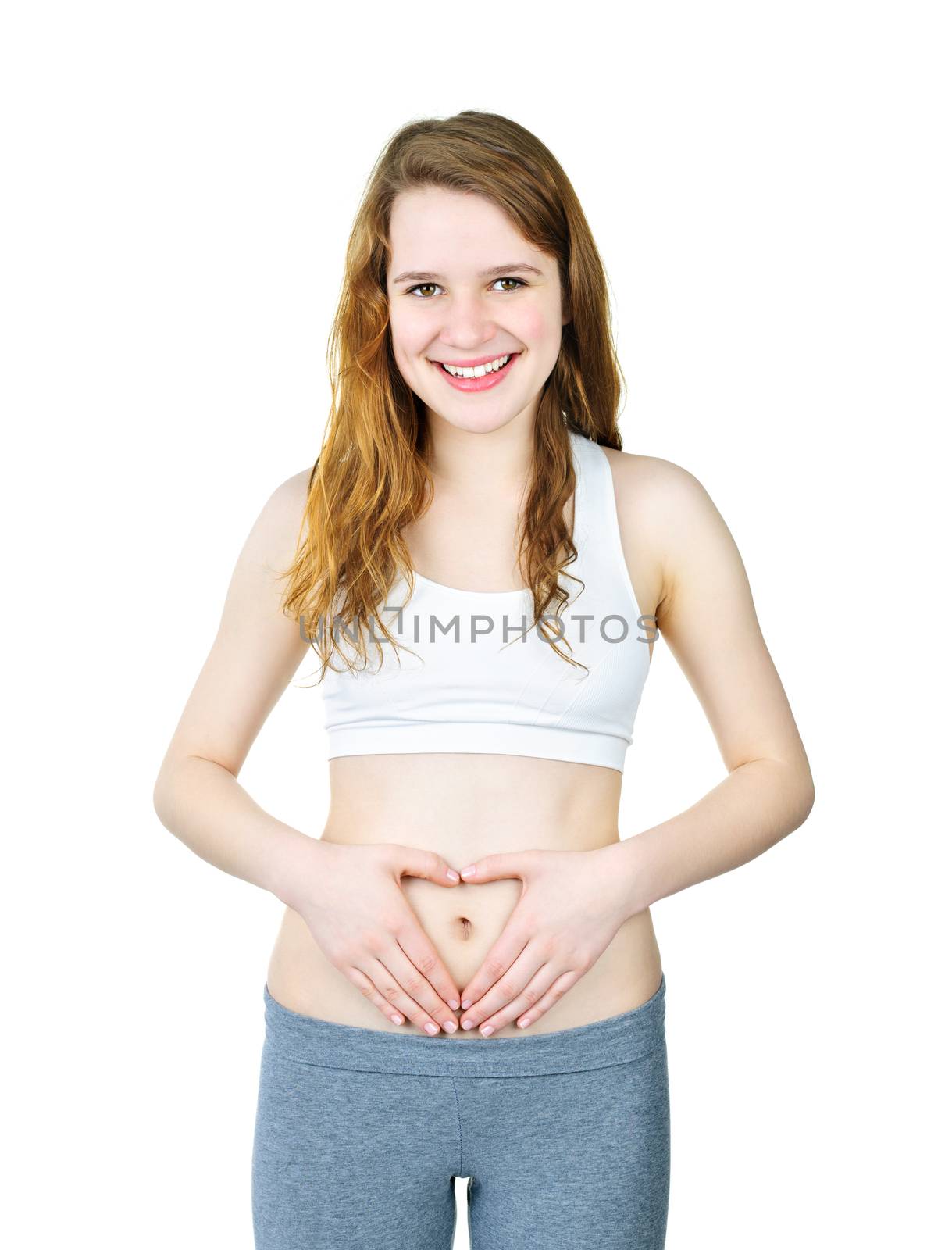 Happy young woman with heart shaped hands on stomach isolated on white