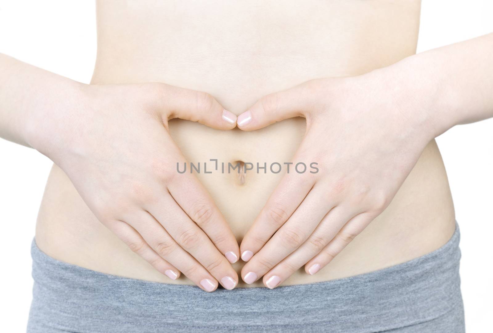 Woman showing heart shape with her hands on stomach