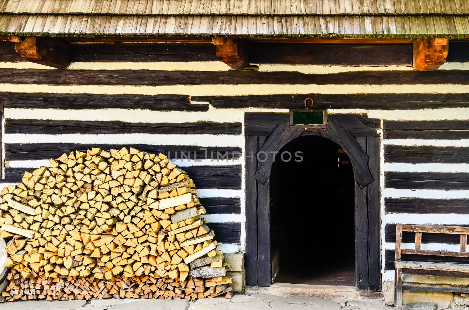 Entrance to traditional old cottage with pile of firewood, Slovakia