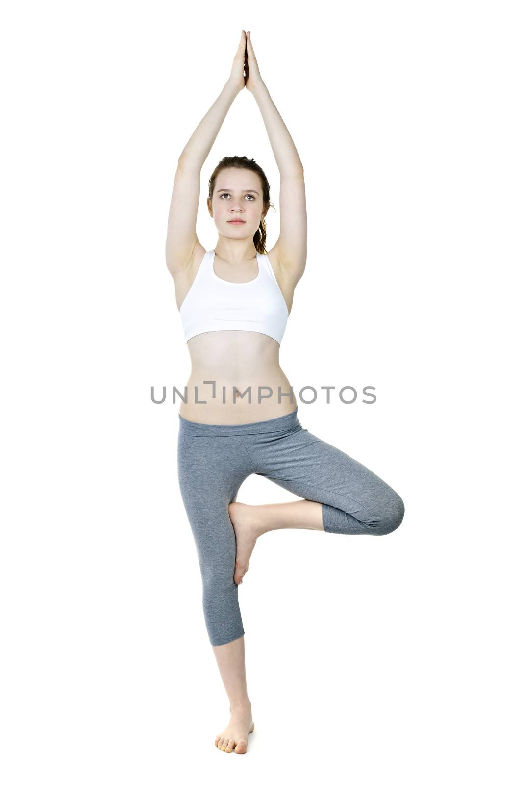 Healthy young woman doing tree yoga pose isolated on white