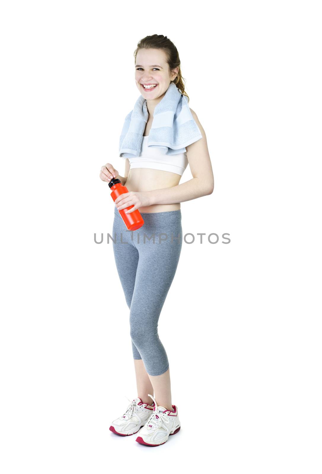 Happy fit young woman after workout with towel and water bottle