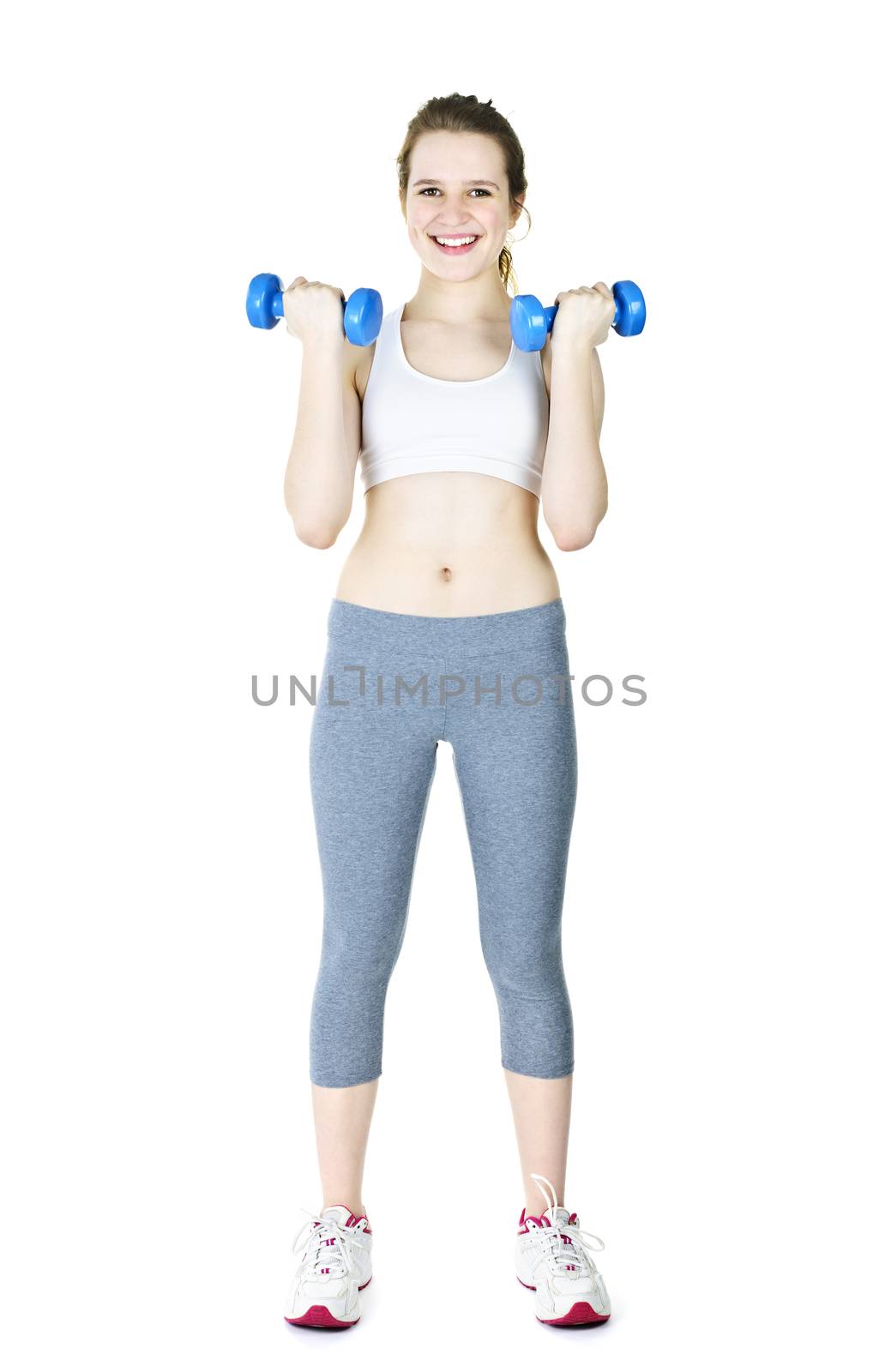 Happy fit young woman working out with weights standing on white background