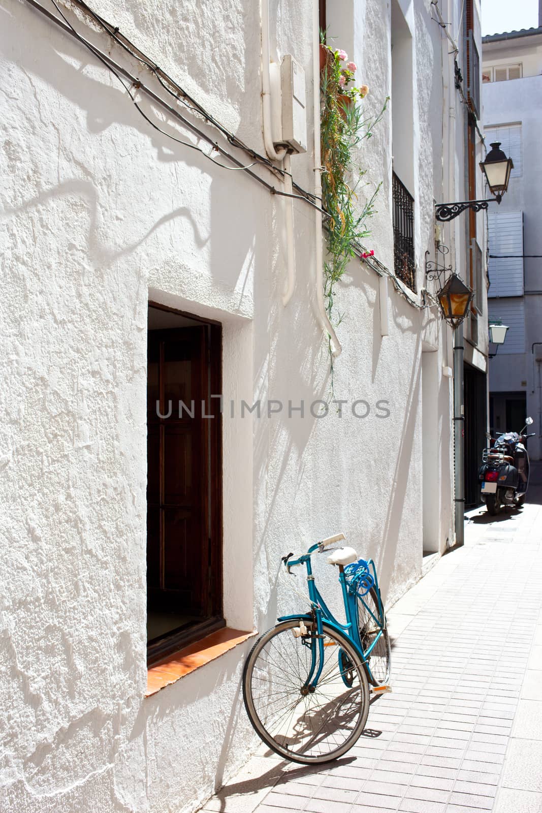 Spanish town street with a bicycle at a white wall