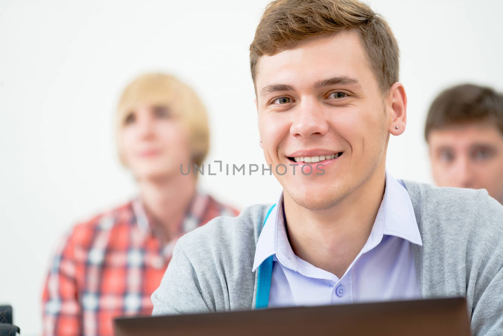 Portrait of a young student in the classroom, working with a laptop