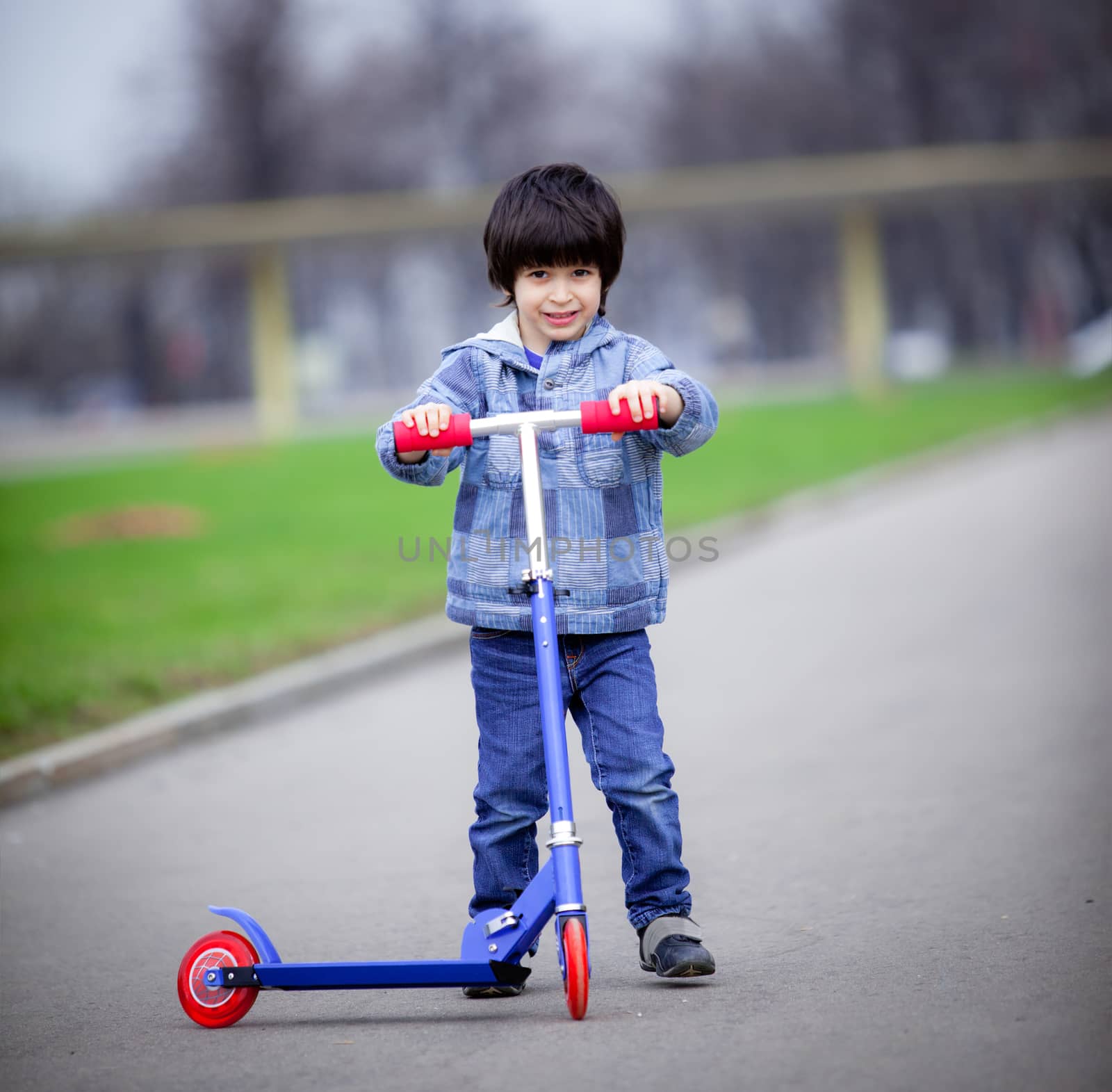 a boy with a new scooter on open air