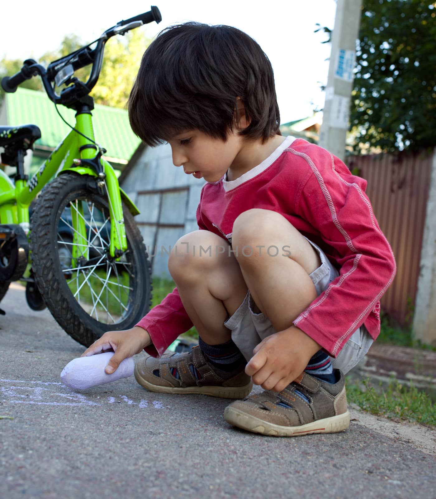 boy  drawing with chalk on asphalt by Astroid
