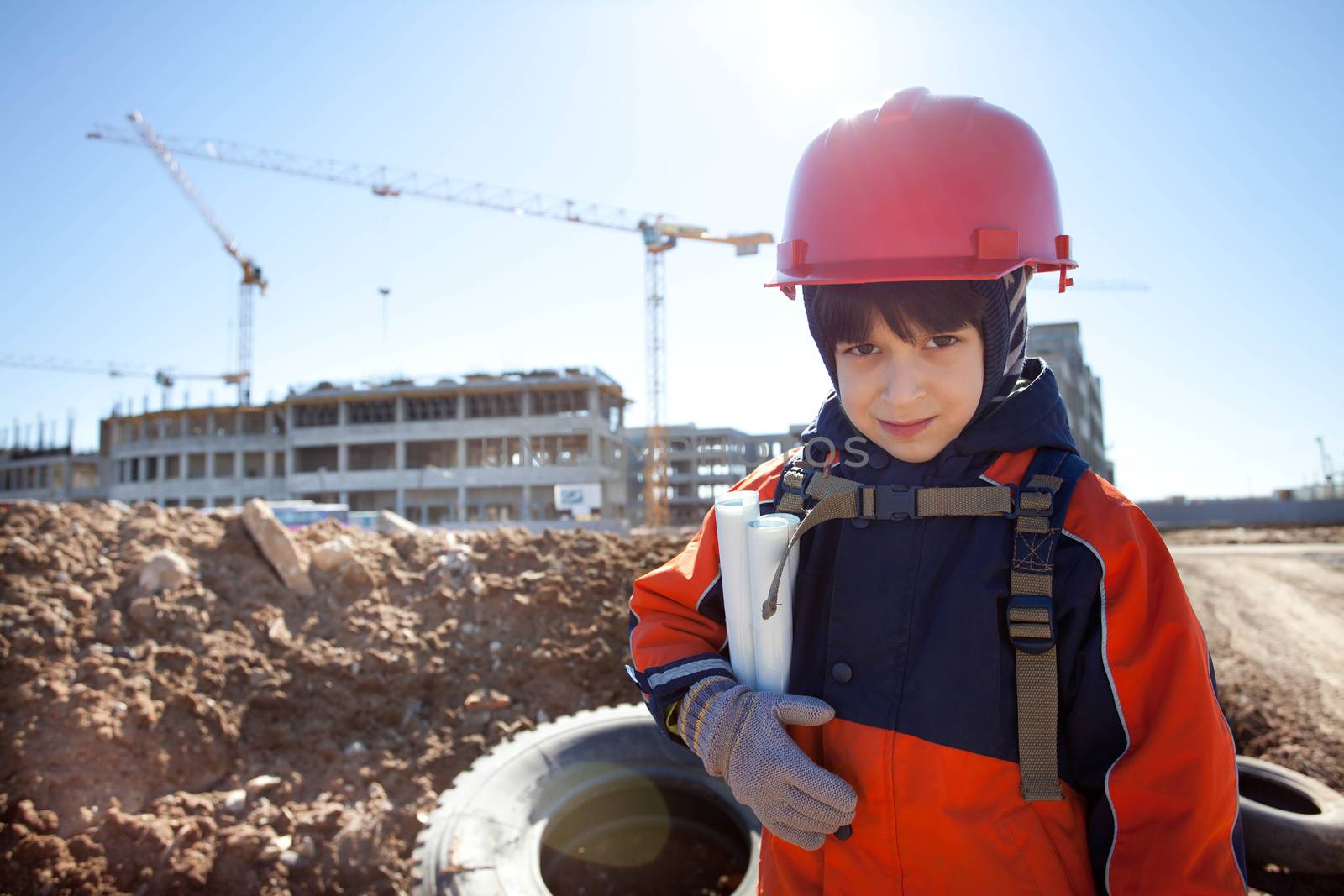 young builder in a red helmet on a background of construction