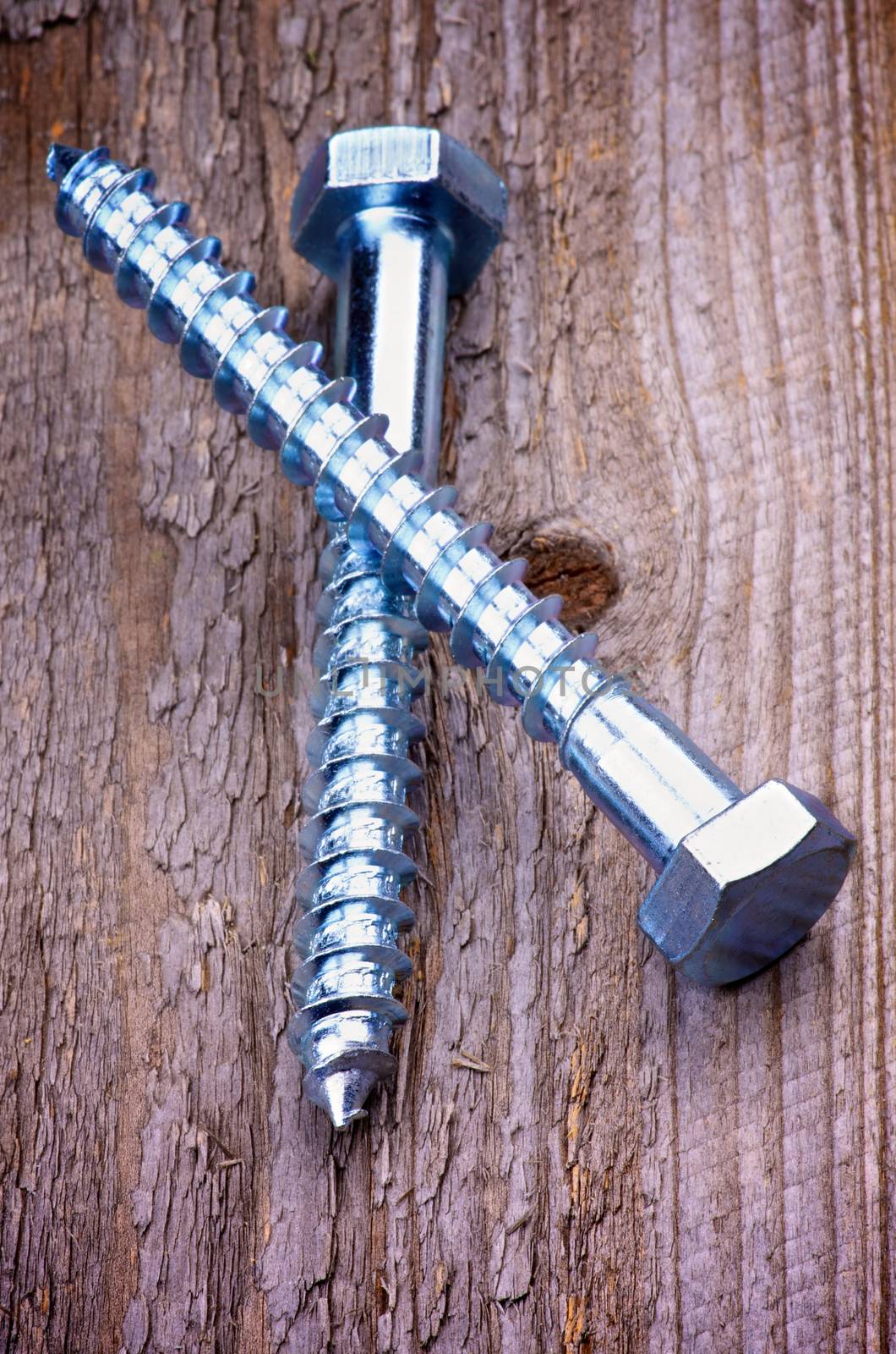 Big Stainless Steel Bolts isolated on Rustic Wooden background