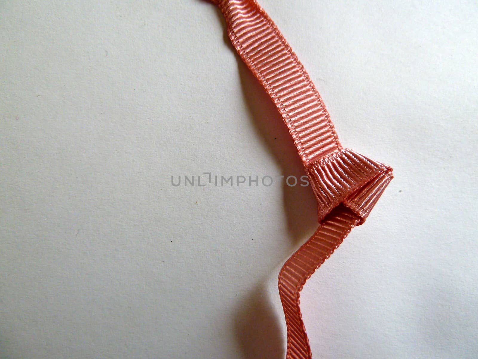 Unusual bright pink knotted ribbon on a white background