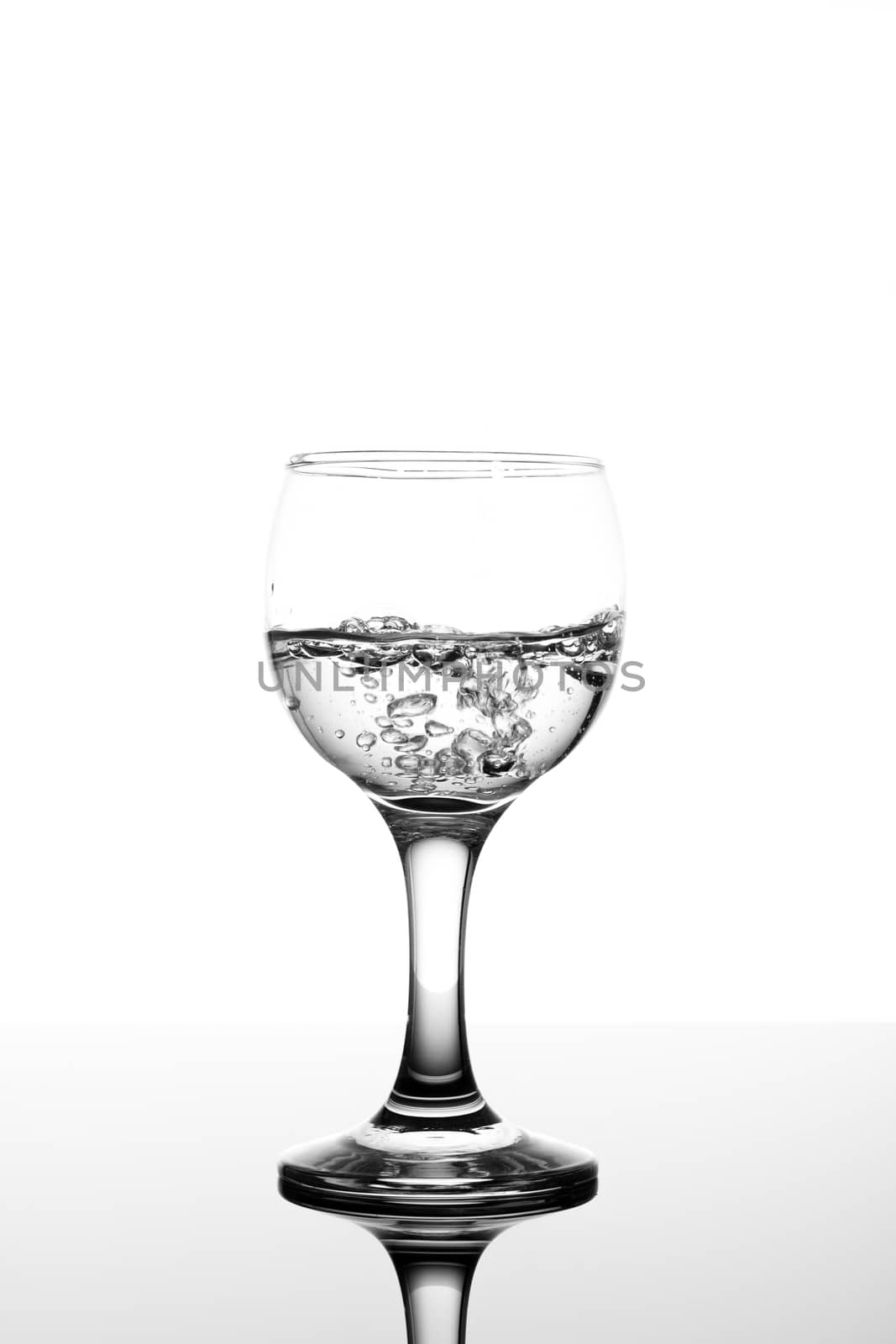 transparent glass with fizzy water on white background