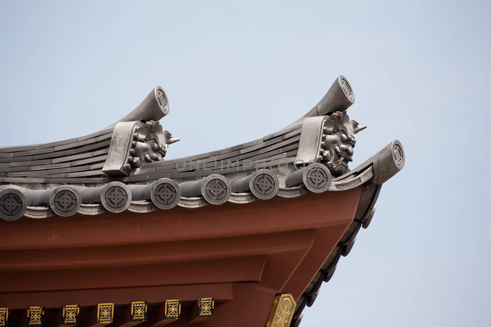 Detail on japanese temple roof against blue sky. by 2nix