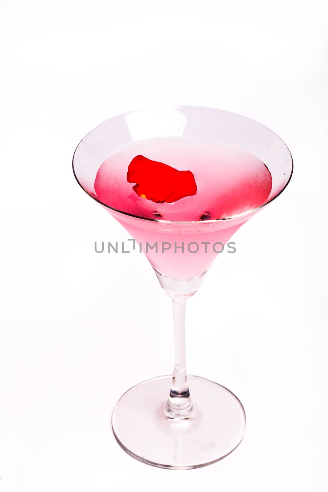 Cosmopolitan cocktail with rose in top of a white background