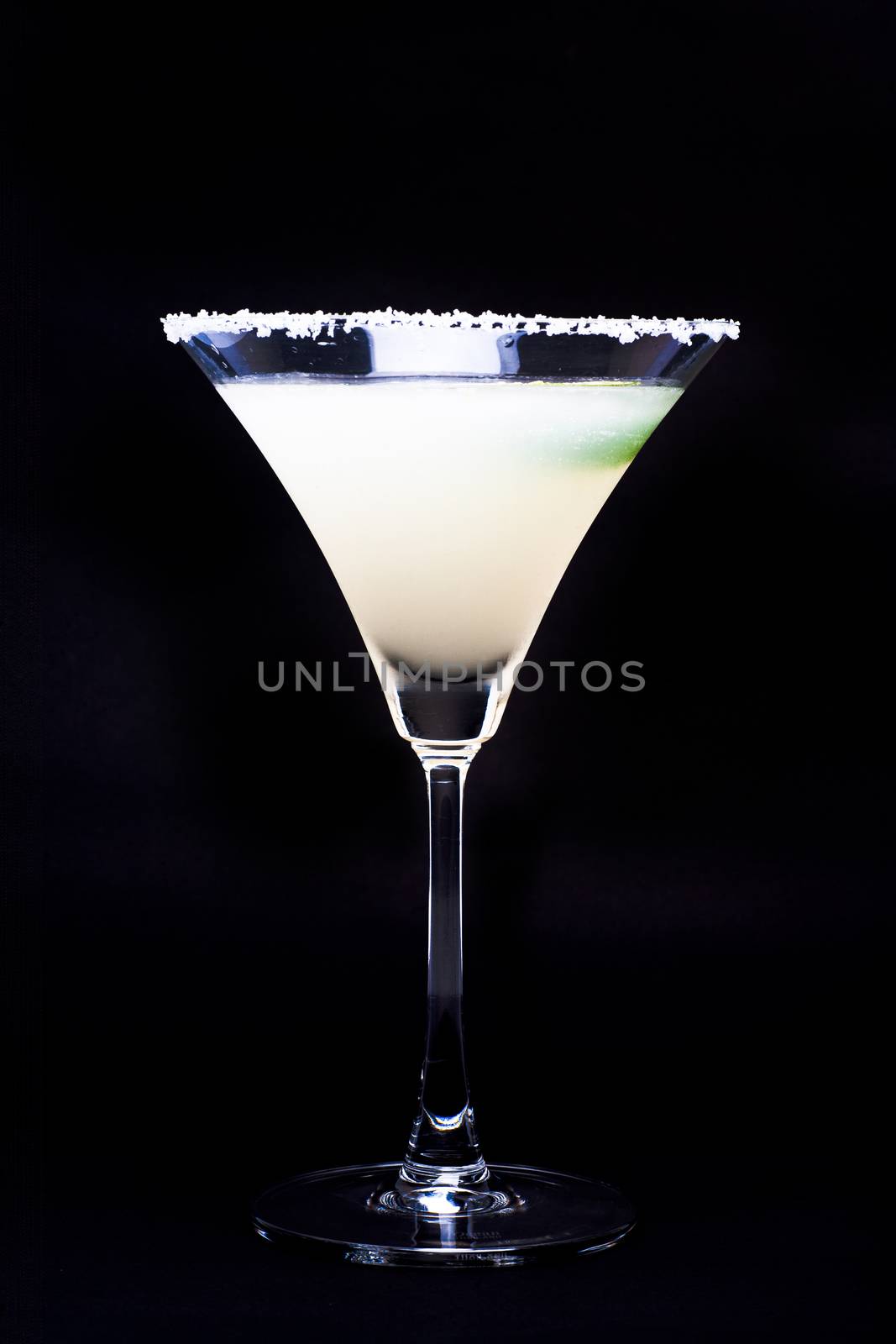 Margarita in glass with lime isolated on black background