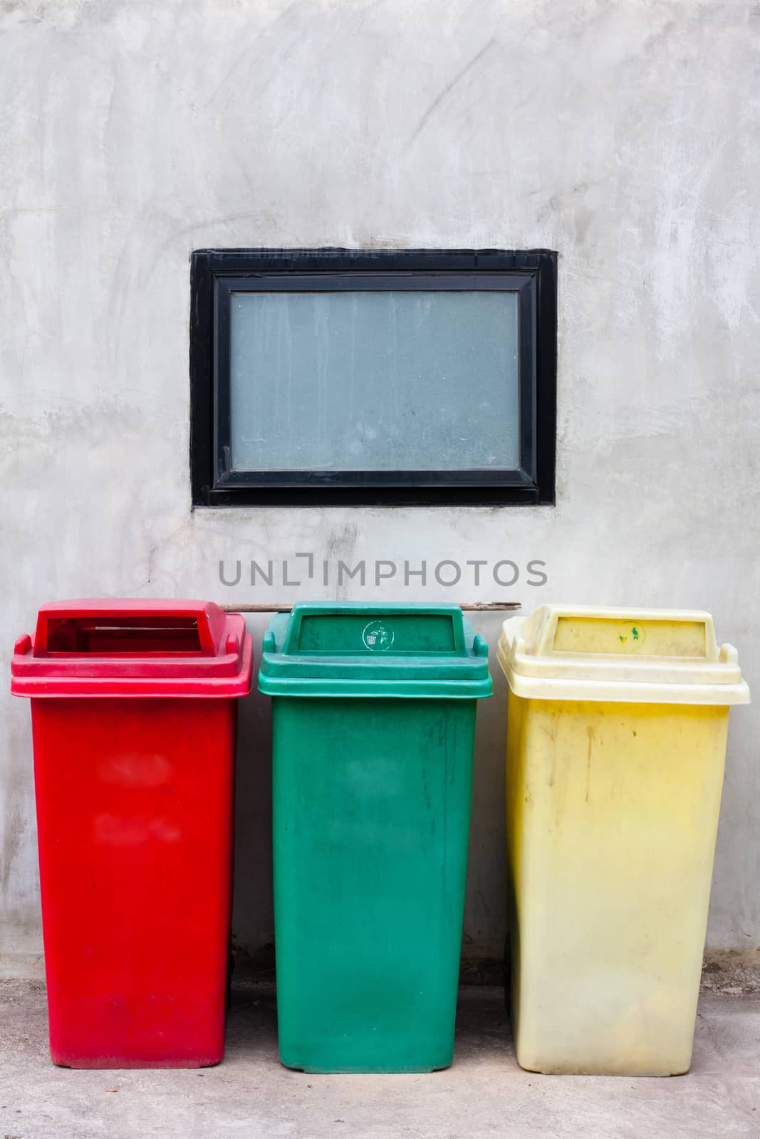 Red green and yellow recycle bin on wall