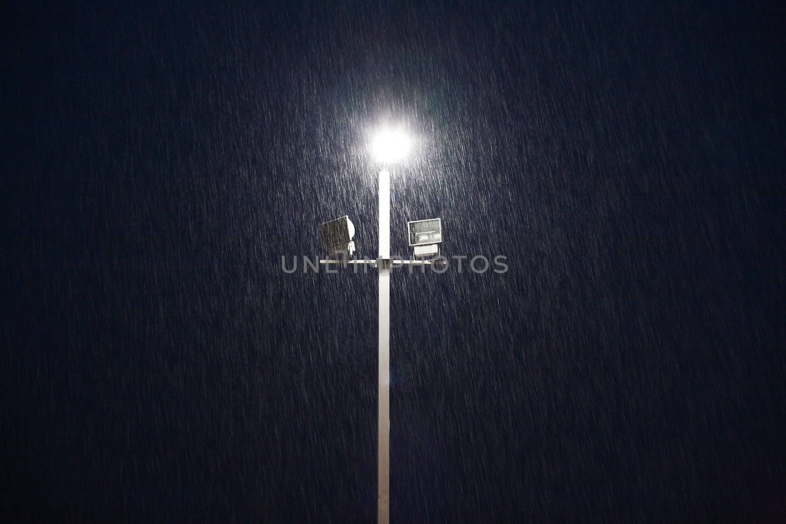 lights on a sports field at evening in the rain