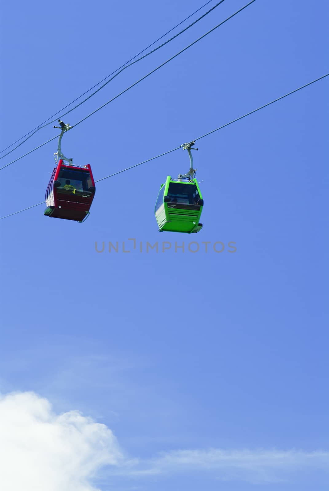 Red and Green cable car lift on blue sky at vietnam
